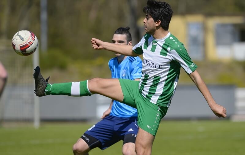 Cihad Ilhan (grün-weißes Trikot) im Zweikampf mit seinem Schwetzinger Gegenspieler Foto: Berno Nix