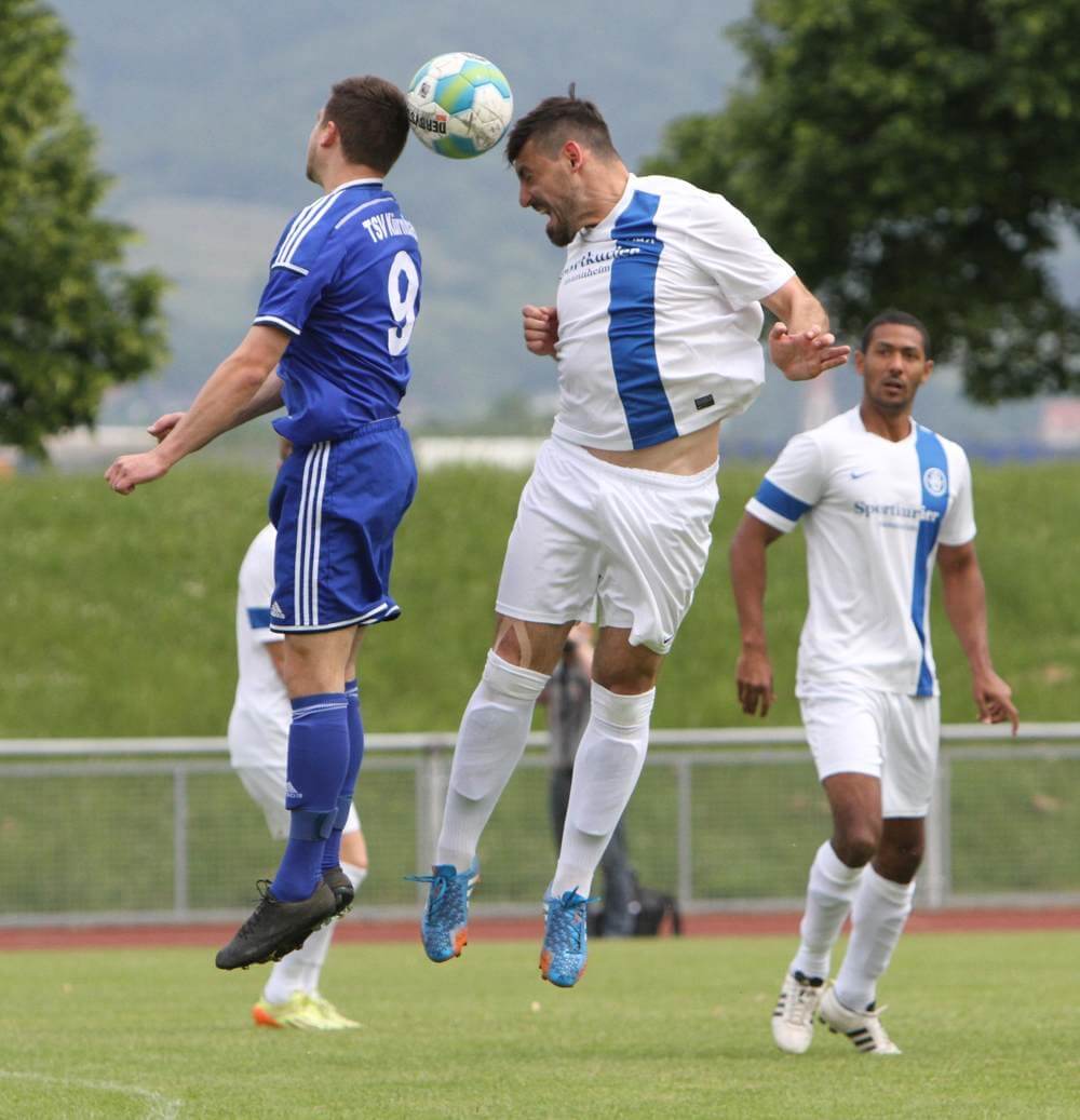 Giovanni Marino (weißes Dress) gewinnt das Kopfballduell gegen seinen Kürnbacher Gegenspieler. Bei Marino gilt: Je älter, desto besser wird der Innenverteidiger. Bild: lofi