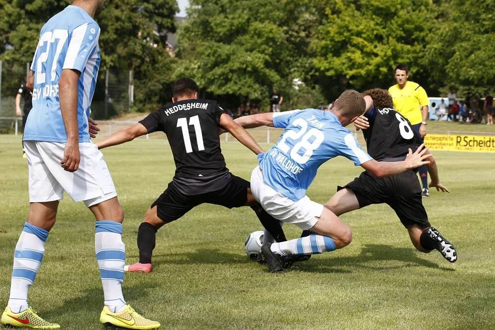 Heddesheims Wegmann (Nr. 8) und Mikail Erdem (Nr.11) kommen vor Waldhofs Benedikt Zahn (Nr. 28) an das Leder. Bild: Rafael Kowollik