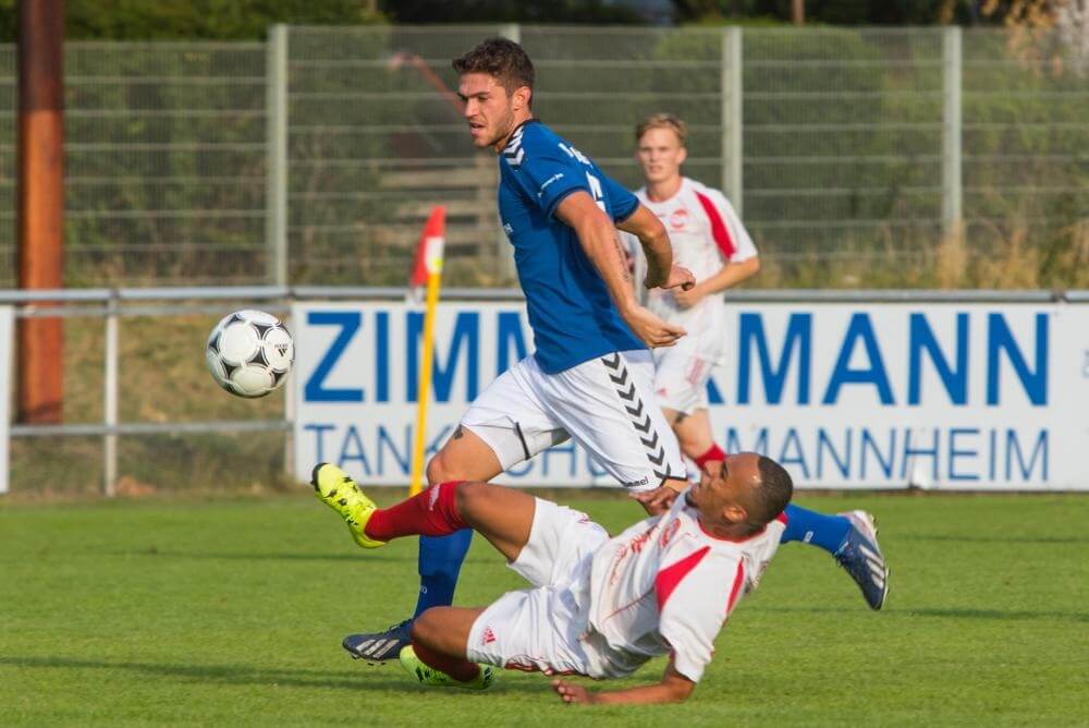 in Blau Mantel / VfR gegen Marcus Hawk / RW, VfR Mannheim vs. RW Reinau.  Bild: AS Sportfotos